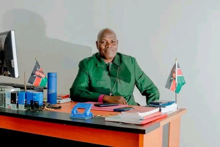 Bsp Joel Okeyo Amonde, Founder and Senior Pastor, seated at his desk at the Agongo headquarters