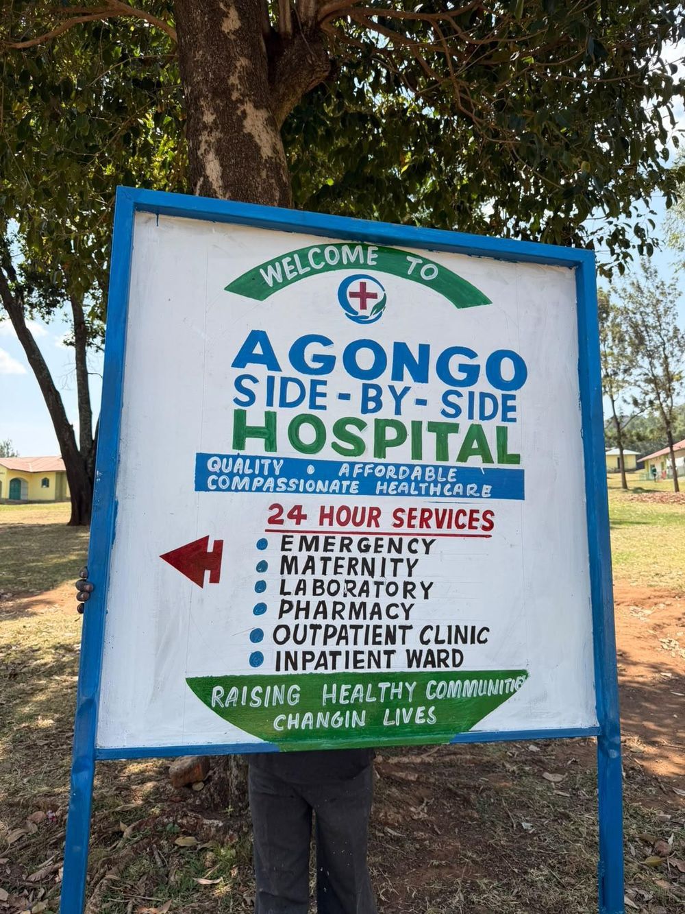 Signage at Agongo Side-by-Side Hospital listing its 24-hour services
